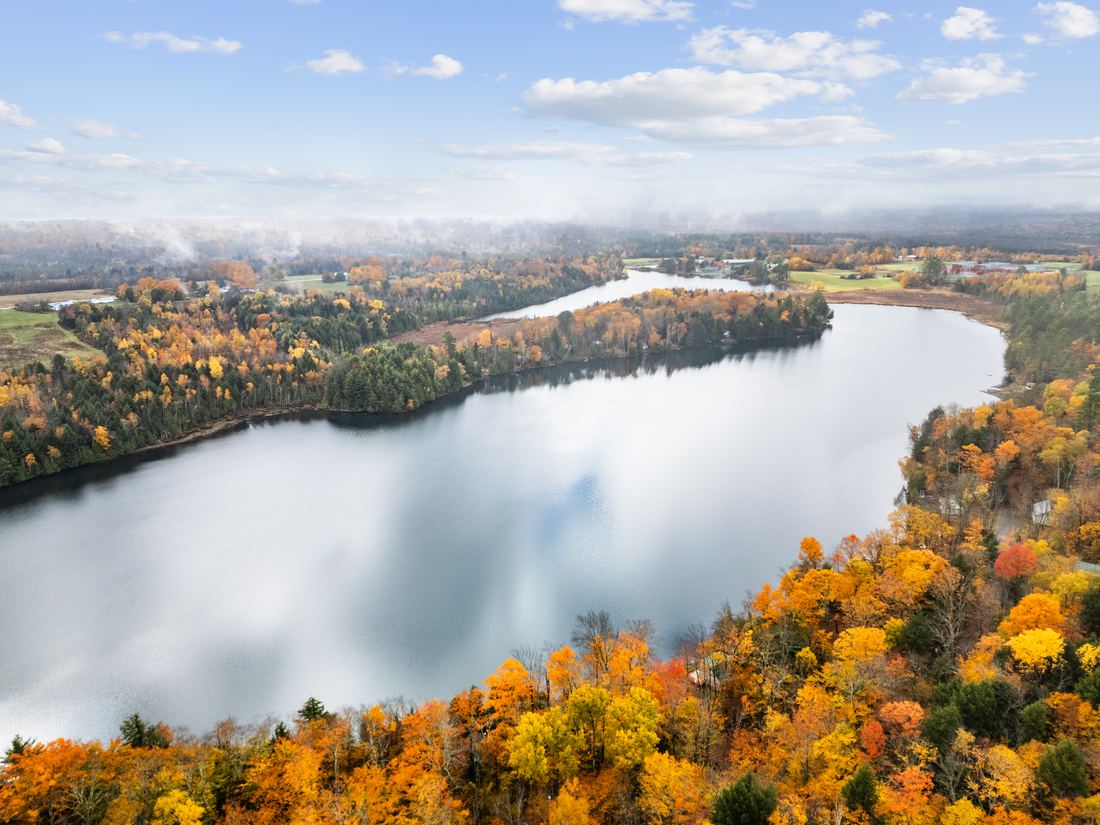Aerial drone photo of a lake with fall foliage