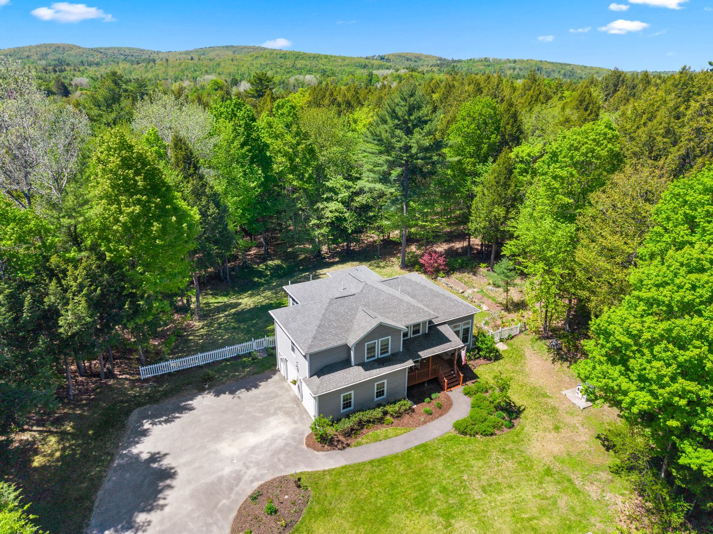 Aerial drone photo of a home surrounded by forest
